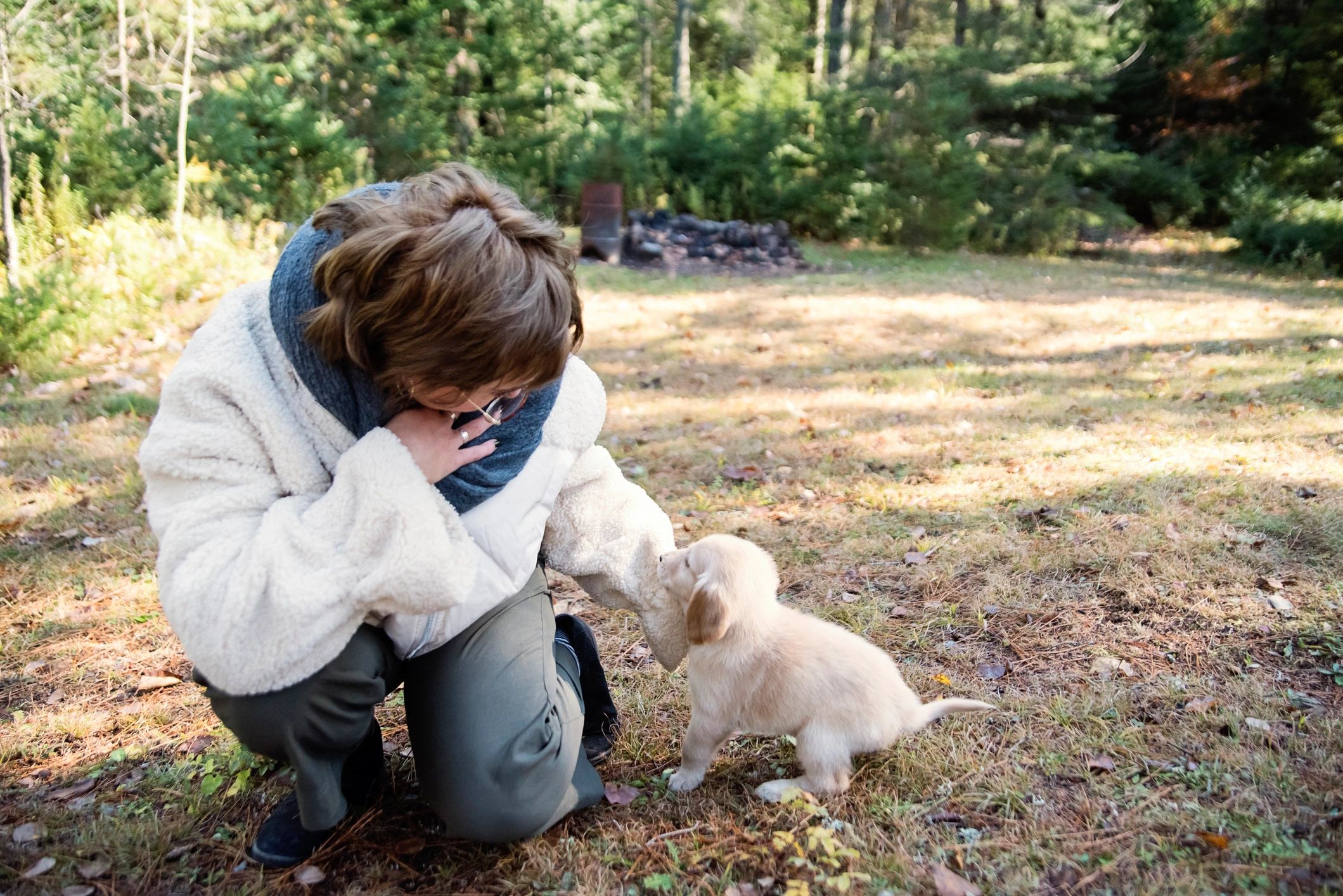 Young woman playing with a puppy outdoors
